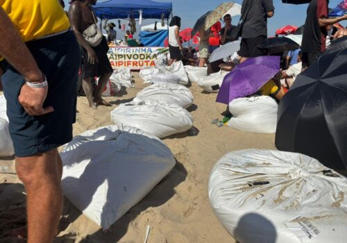 Ambulantes vendem sacos de areia e banquinhos de plástico para servir de 'camarote' durante show da Shakira